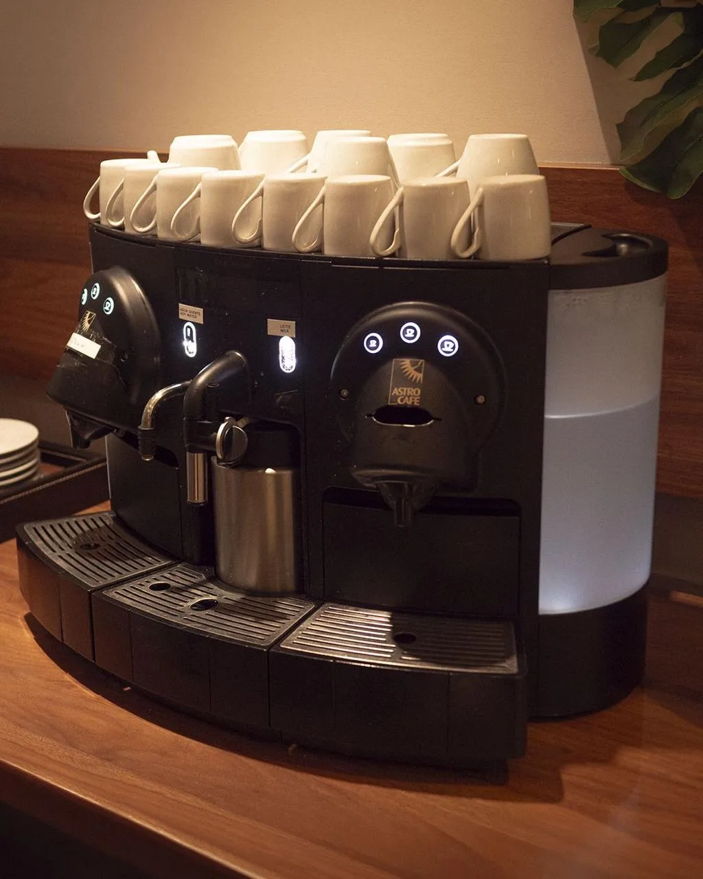 Estação de café com xícaras e máquina profissional
