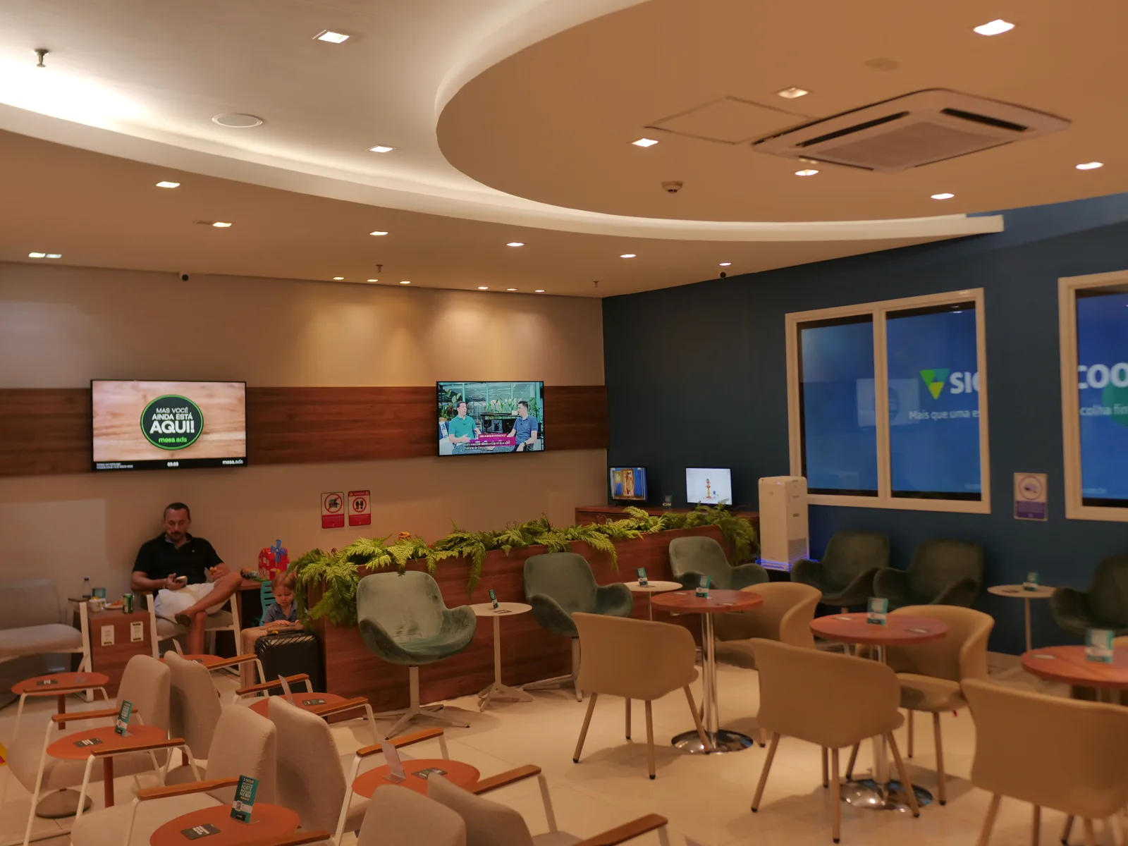 Poltronas verdes e ambiente climatizado do lounge